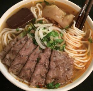 “Chinese chow mein noodles served with chicken and fresh vegetables”