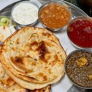 "Traditional Indian thaali with rice, curry, roti, and vegetables"